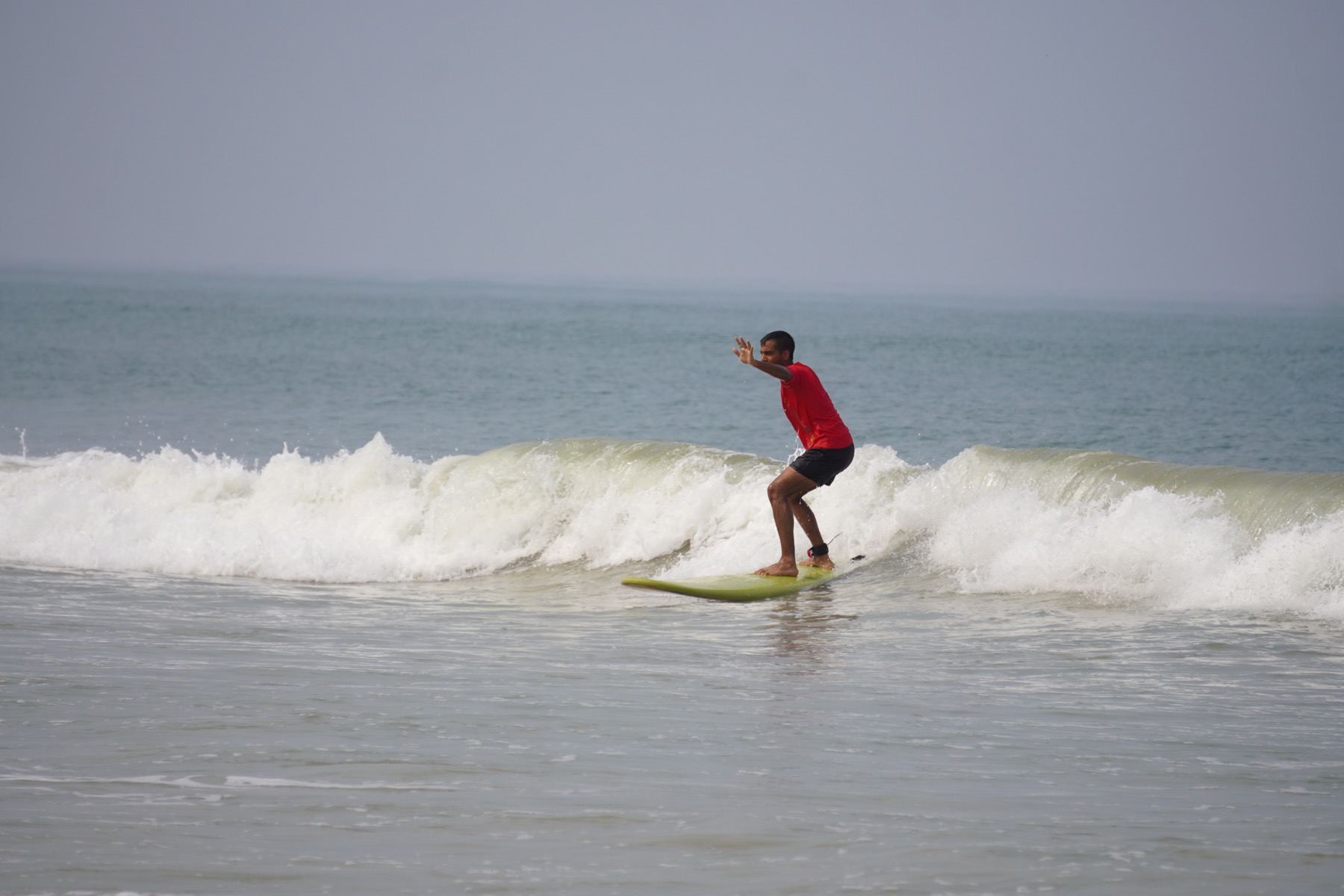Vikram Singh Kushwaha surfing — standing ride on a wave